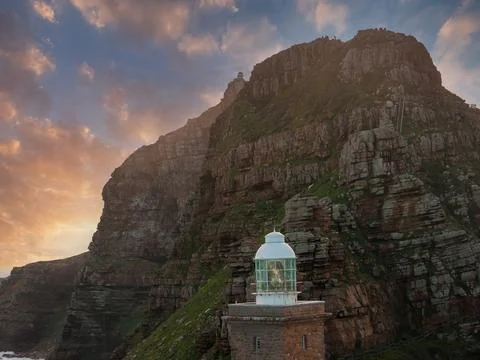 Cape Point lighthouse at cliff base in South Africa at sunset Stock Photos