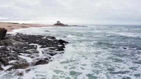 Capela do Senhor da Pedra church on the sandy pinissula washed by winter cold At Vidéo 302947427