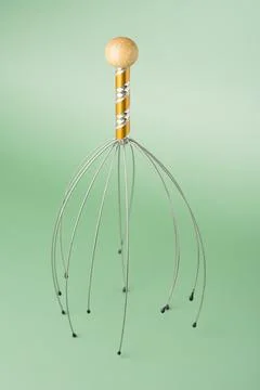 Capillary head massager on mint background. Metal antistress massage tool. Sm 스톡 사진