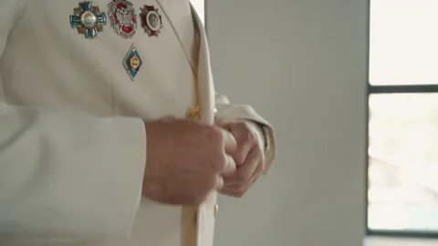 Capital man buttons up his jacket and poses for camera in modern interior. 動画素材 148007831