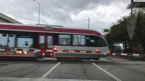 A Capital MetroRail train speeds down the tracks through a railroad crossing Stock Footage 136447194