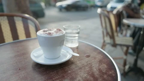 Cappuccino on Cafe Table at Sunset with Blurred Street in Paris France Stockbeeldmateriaal 323916148