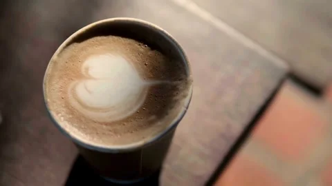 Cappuccino with heart-shaped foam on a table. Art's Latte in a coffee cup. 動画素材 334648873