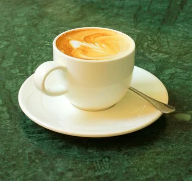 Cappuccino or latte coffee on table with flower chair Stockfoto's