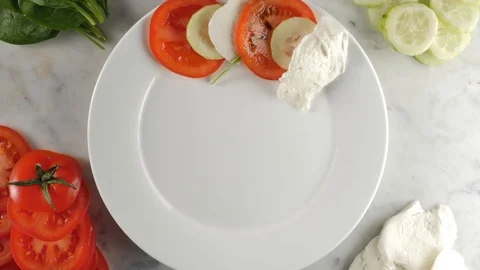 Caprese salad stop motion, top view. Healthy vegetarian salad with sliced tomato 動画素材 123428573