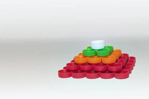 Caps of plastic bottles, collected in regular quadrangular pyramid Stock Photos
