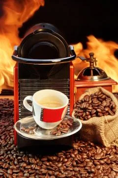 Capsule coffee machine with  espresso cup near fireplace Stock Photos