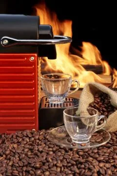 Capsule coffee machine with two espresso cups near fireplace Stock Photos