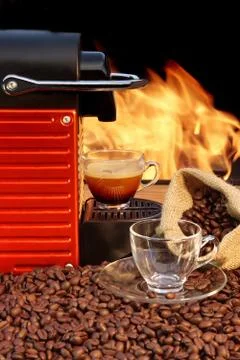 Capsule coffee machine with two espresso cups near fireplace Stock Photos