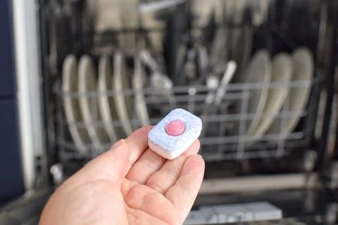Capsule with detergent on the background of a dishwasher Stock Photos