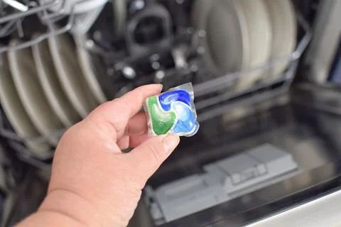 Capsule with detergent on the background of a dishwasher Stock Photos