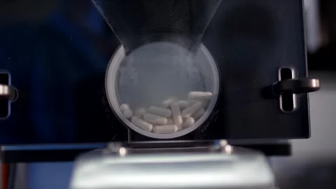 Capsule Filling Machine Dosing White Pills, Pharmaceutical Plant, Close Up Shot Stockbeeldmateriaal 341331306