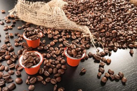 Capsule with grain coffee on dark Stock Photos