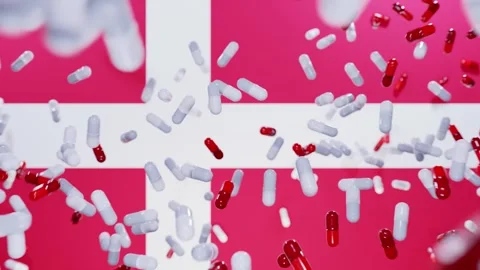 Capsule pills fall on a flag of Denmark. The Pharmaceutical Industry in Denmark Stock Footage 257930882