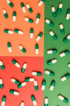 Capsule pills pattern on a colored background. Stock Photos