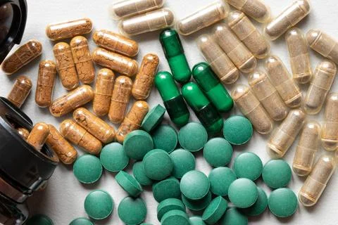 Capsules and green tablets on a light background and a jar, related to medici Foto stock