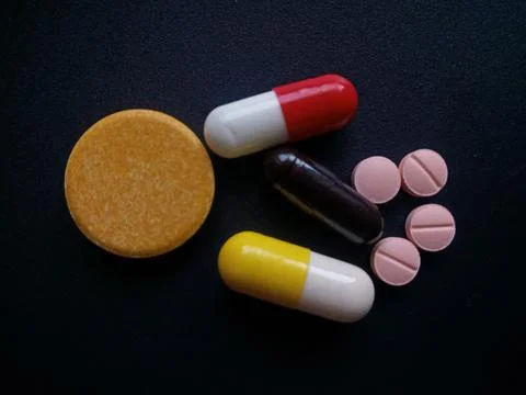 Capsules and tablets on black background. Foto stock
