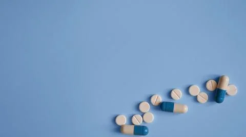 Capsules and tablets on a blue background, photos for a medical website, me.. Stock Photos