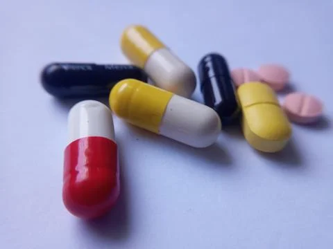 Capsules and tablets on white background, red, yellow, black and pink color. Foto stock
