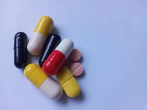 Capsules and tablets on white background, red, yellow, black and pink color. Foto stock