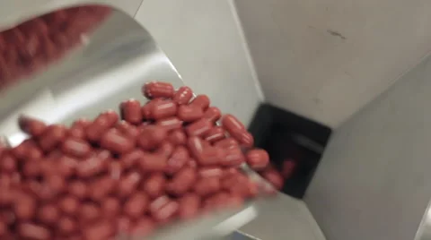 Capsules being Poured into a Pill Sorting Machine Stock Footage 68641980