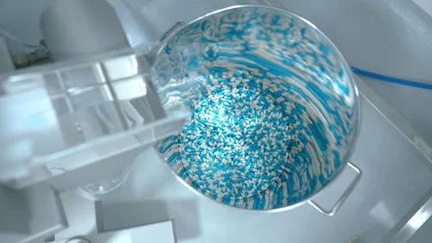 Capsules collecting in a large container. dropping capsules from a machine. caps Stock Footage 290160109