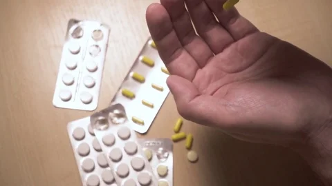 Capsules fall on the man's palm slow motion Stock Footage 83685140