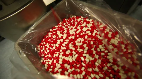 Capsules falling into a vat Video stock 38017545