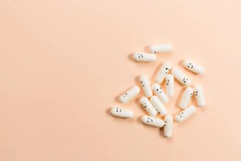 Capsules with painted emotions on a solid background. Stock Photos