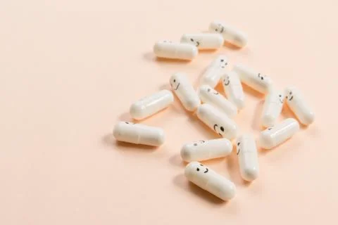 Capsules with painted emotions on a solid background. Stock Photos