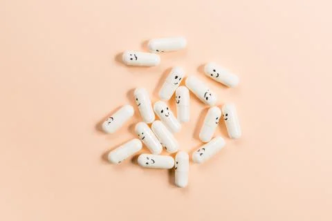 Capsules with painted emotions on a solid background. Stock Photos