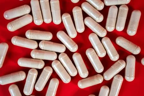 Capsules scattered close-up macro on red background Stock Photos