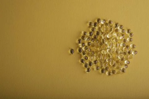 Capsules in a shell with liquid vitamin D3 on a yellow background Foto stock