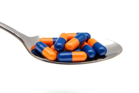 Capsules in a spoon Stock Photos