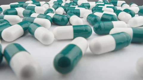 Capsules with vitamins and supplements move on the platform in rotation mode Video stock 254955338