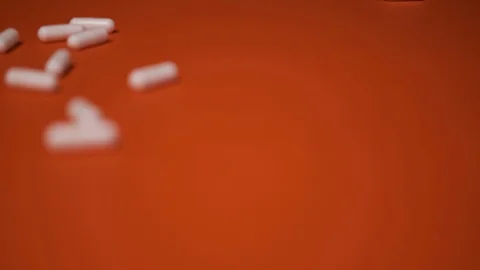 Capsules, white tablets lie, roll on a red table, background, medicine, virus Stock Footage 125351569