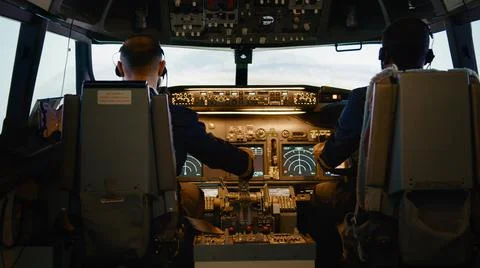 Captain and copilot throttling engine handle to fly airplane Photos