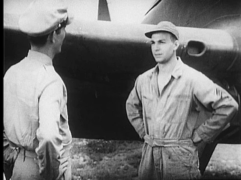 A captain and a flight crew chief talk; a lieutenant, the pilot, does an Stock Footage 75291436