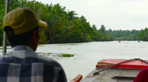 Captain Driving Tourists on sight-seeing boat on The Mekong Delta river Stock Footage 55401287