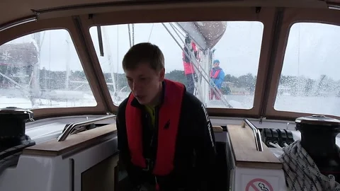 Captain goes up into cabin of yacht team prepares ship sail Stock Footage 168361663