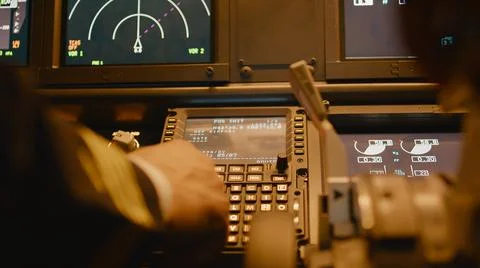 Captain inserting destination coordinates on cabin dashboard Stock Photos