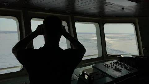 The captain looks through binoculars from the icebreaker's control room. Stock Footage 148228619