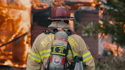 Captain observing a fire's behavior as it fully engulfs structure. Stock Footage 201961913
