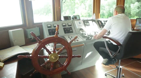 Captain operates a motor boat in the deckhouse Stockbeeldmateriaal 35664208