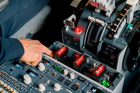 The captain presses the buttons on the control panel to start the engine of the Stock Photos