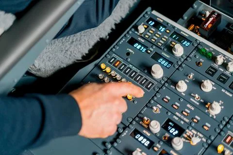 The captain presses the buttons on the control panel to start the engine of the Stock Photos