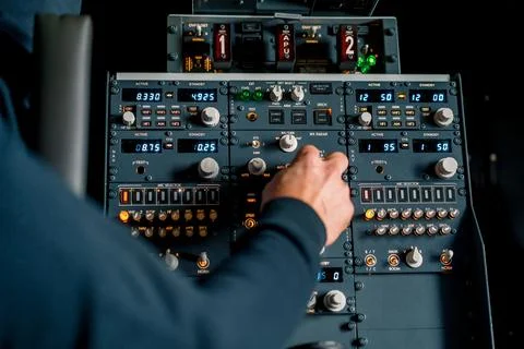 The captain presses the buttons on the control panel to start the engine of the Stock Photos