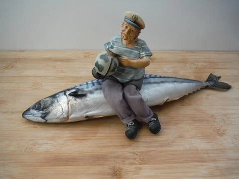 The captain of the ship with a beard and a globe in his hands sits on a fish. Stock-Fotos