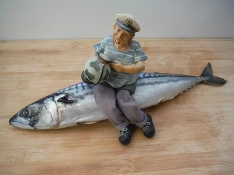The captain of the ship with a beard and a globe in his hands sits on a fish. Stock Photos