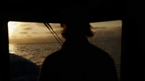 The captain of the ship controls the boat against the backdrop of sunset. The Stock Footage 220768191